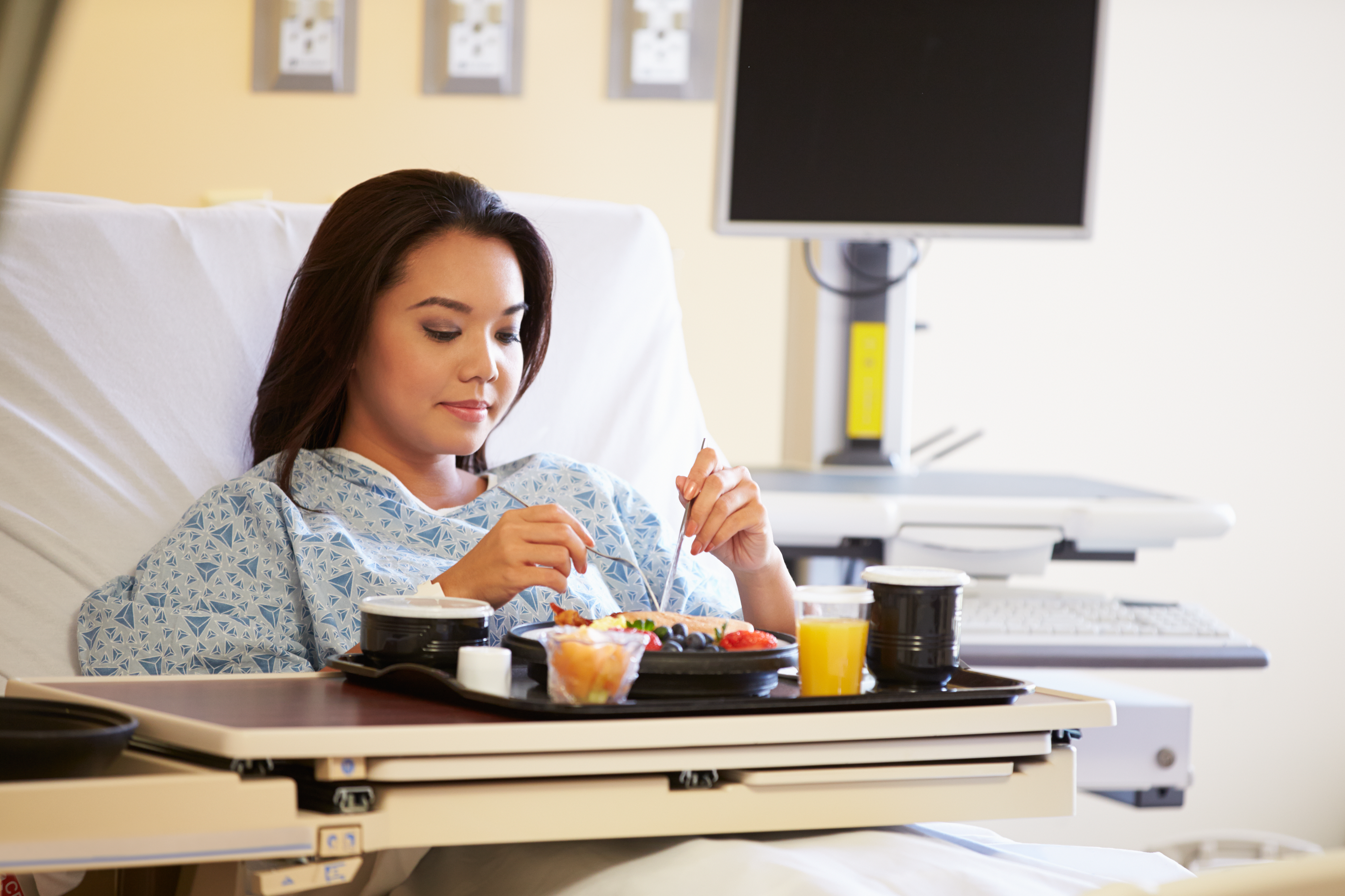 Woman in hospital bed with food